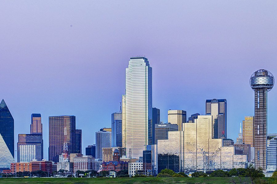 Contact - Long Distance Aerial View of Dallas With Many Tall Buildings on a Bright Day With a Blue Sky